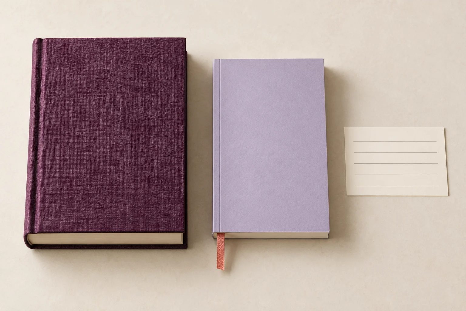 A thick book, a slim book, and a card arranged on a light-colored surface.